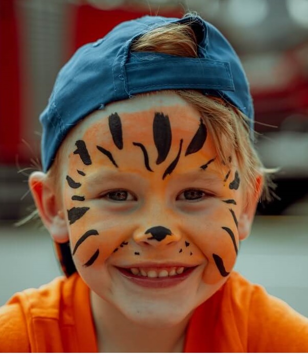 Boy face painted with tiger paws